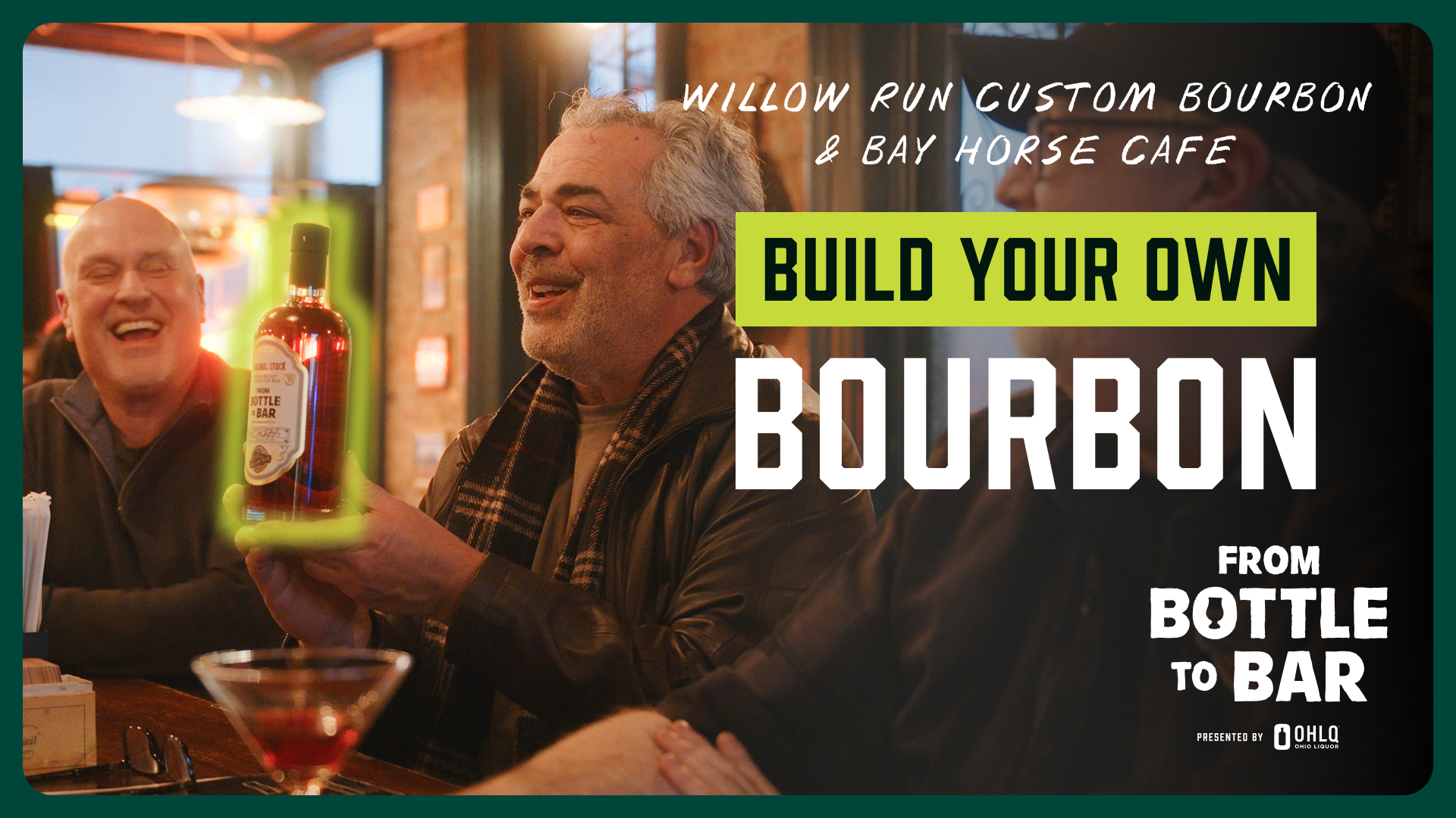 Three smiling men sit at a bar table. The man in the center holds a Willow Run Custom Bourbon bottle. Text reads: “Willow Run Custom Bourbon & Bay Horse Cafe. Build Your Own Bourbon. From Bottle to Bar.”.