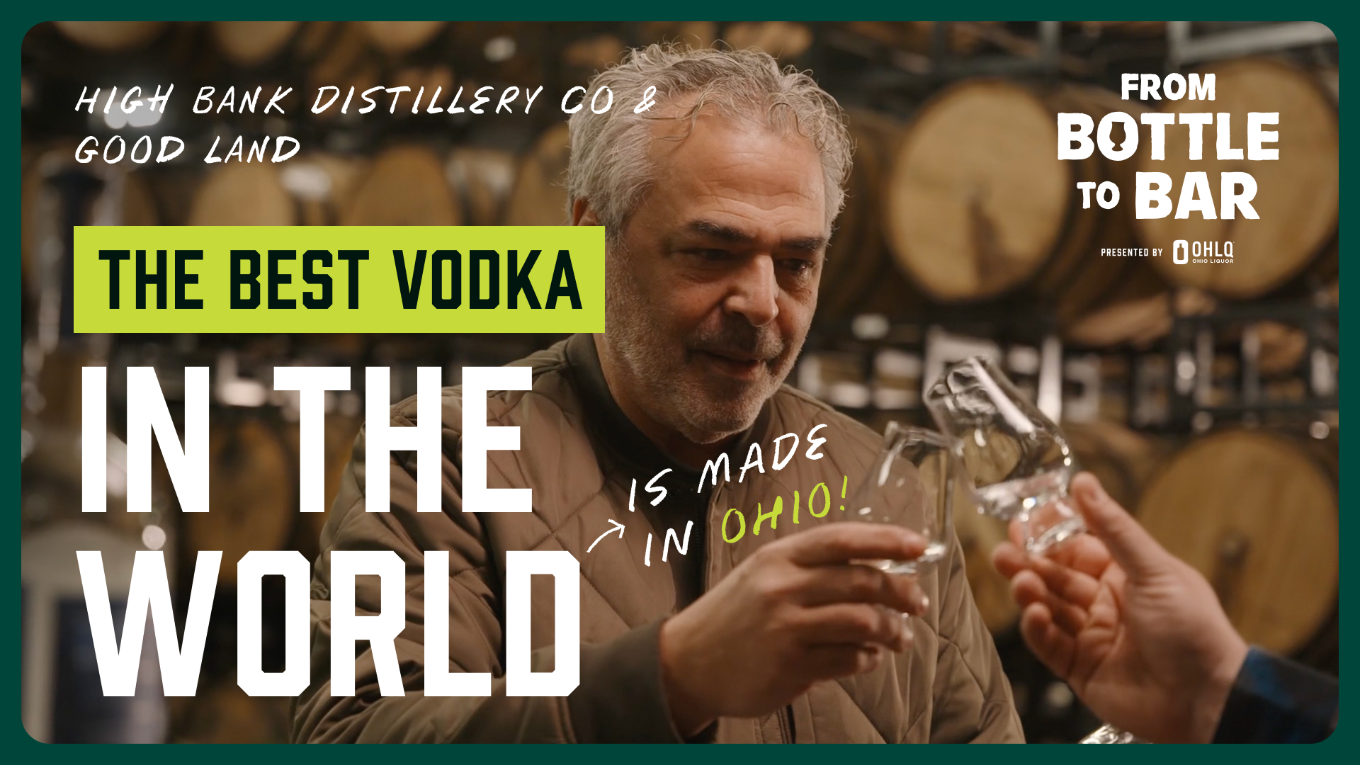 A man in a brown jacket clinks glasses with someone in a distillery, surrounded by barrels and a text overlay: The best vodka in the world is made in Ohio!—right where Cleveland Whiskey meets Wine Dive.