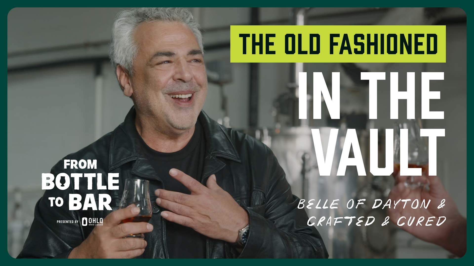 A man in a leather jacket smiles while holding a drink. Text reads: The Old Fashioned In The Vault. From Bottle to Bar—Belle of Dayton & Crafted & Cured, featuring spirits from Towpath Distillery. An industrial background sets the scene, reminiscent of nights at The Green Dragon Inn.